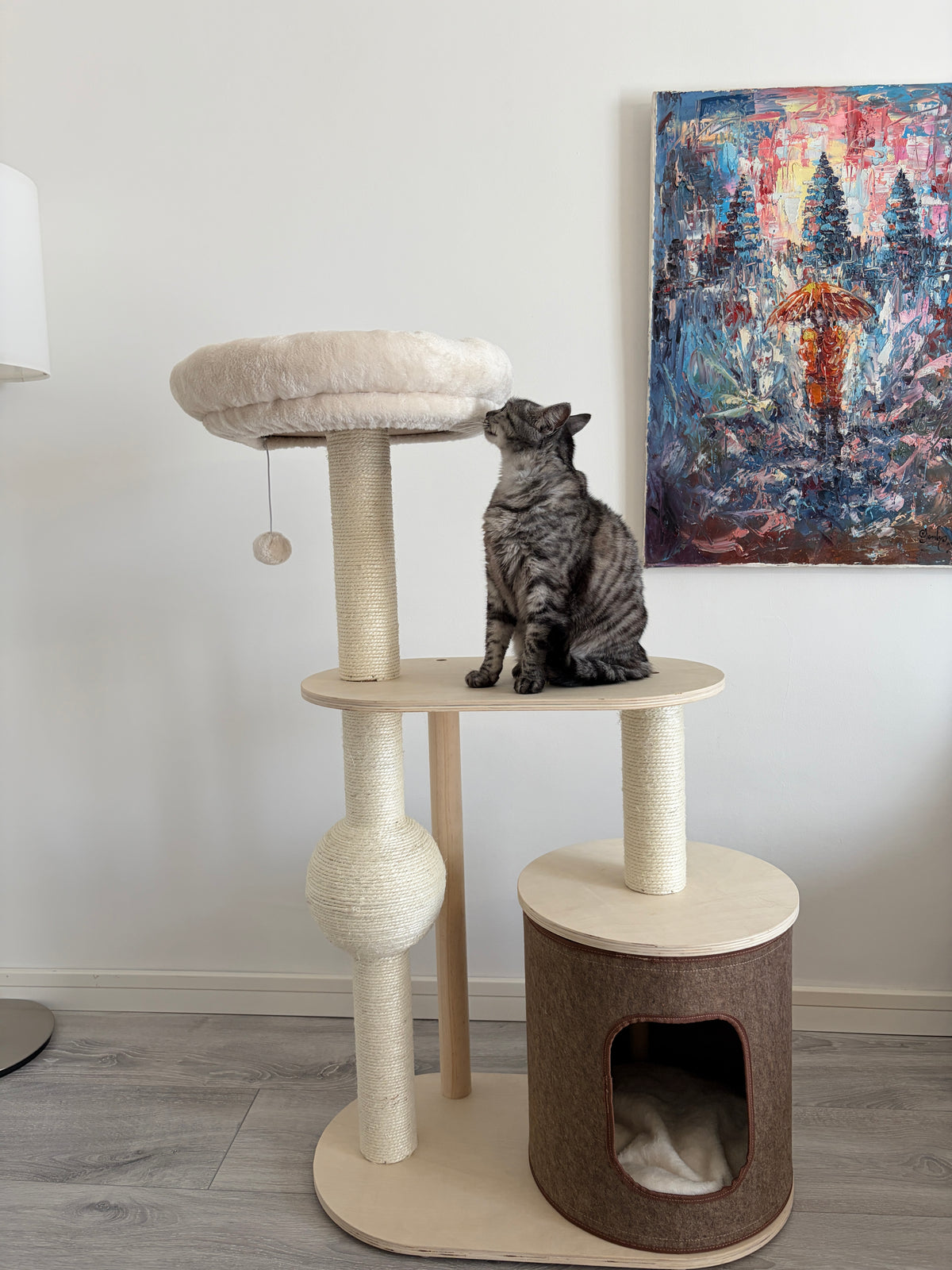 Pisica asezata pe platforma ansamblului de joaca IVORY HAVEN – Meraki Home, cu culcus suspendat si casuta pentru odihna.