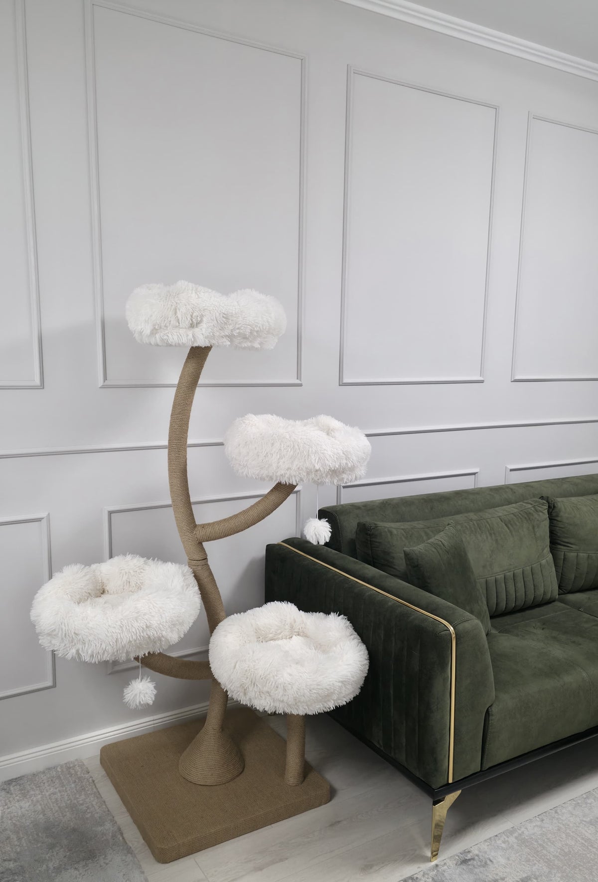 Ansamblu de joaca pentru pisici DAISY CANOPY – Meraki Home, cu patru culcusuri albe si structura metalica ramificata, langa o canapea verde.